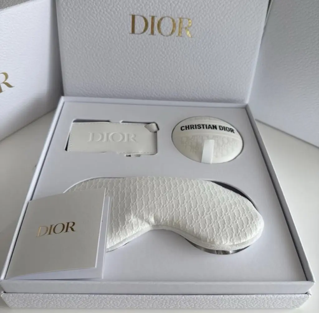 مجموعة هدايا عيد الميلاد للأعضاء من الفئة البلاتينية لعام 2026: كريم Dior Le Baume (سعة 50 مل)، وقناع للعينين، وبطاقة تعريف للأمتعة.