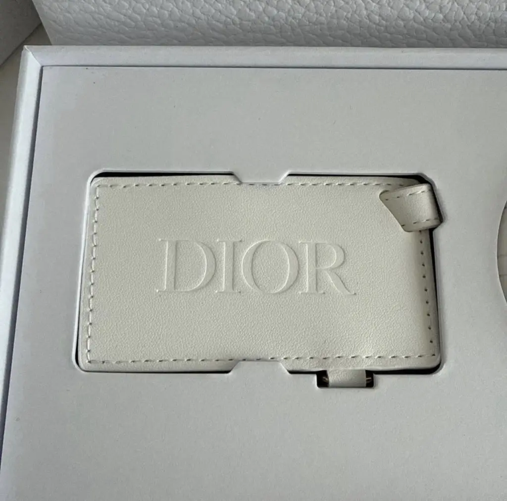 مجموعة هدايا عيد الميلاد للأعضاء من الفئة البلاتينية لعام 2026: كريم Dior Le Baume (سعة 50 مل)، وقناع للعينين، وبطاقة تعريف للأمتعة.